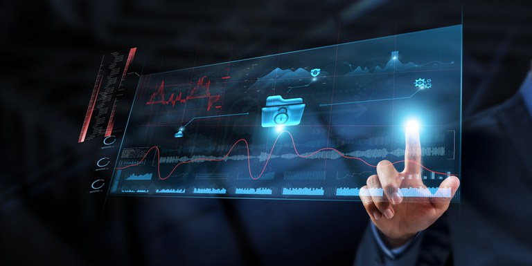 Uma mão, vestindo um terno escuro, estende o dedo indicador e toca uma tela de projeção digital transparente e brilhante. Na tela, gráficos de ondas vermelhas e azuis se espalham horizontalmente, e no centro, um ícone de pasta azul com um cadeado simboliza dados seguros ou acesso a informações. A imagem sugere conceitos de tecnologia, análise de dados, segurança digital ou gestão financeira high-tech.