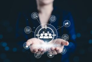 Mãos em postura de acolhimento sustentam um brilho central do qual emanam diversos ícones digitais, representando estratégias de marketing digital e o foco no público-alvo.