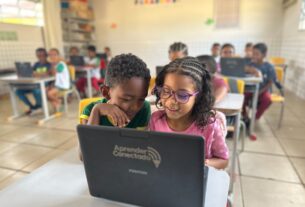 Duas crianças utilizam um notebook
