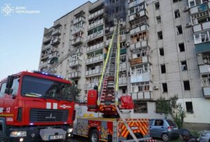 Bombeiros contendo fogo em prédio atingido por ataque na cidade de Smila