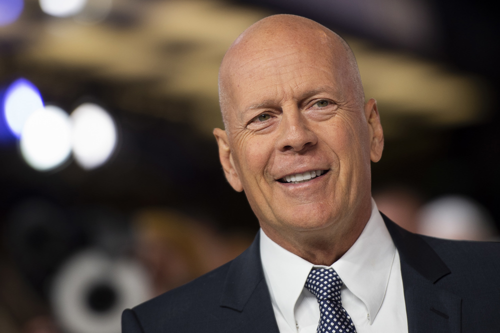 Bruce Willis de terno durante tapete vermelho de cerimônia