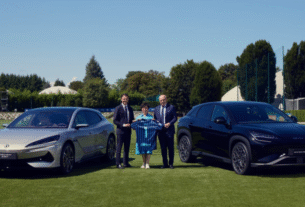 Representantes do clube italiano posam com os carros da BYD, segurando a camisa da Inter de Milão ao lado de Stella Li, vice-presidente executiva da BYD